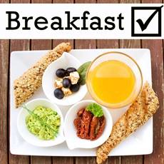 orange juice, whole grain bread with seeds, blueberry, dry tomatoes and guacamole on a white rectangular dish