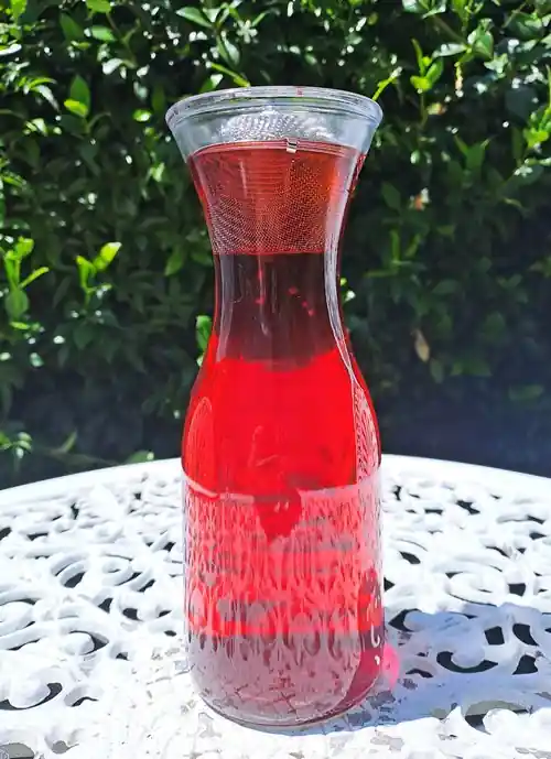 red hibiscus tea in glass bottle