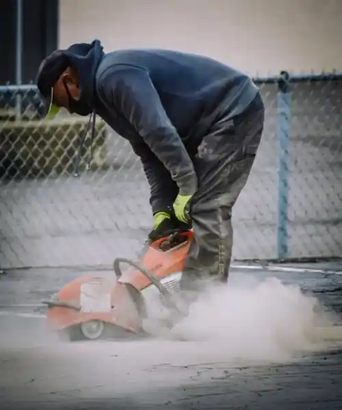 man cutting concrete with handtool
